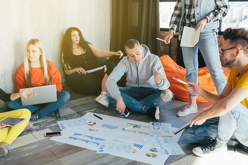 young people sitting on the floor planning business strategy